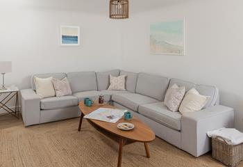 The sitting room offers space to relax and unwind, surrounded by coastal artwork.