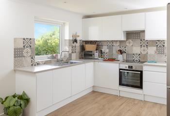 The kitchen features a modern and sleek design, plenty of space for cooking a feast!