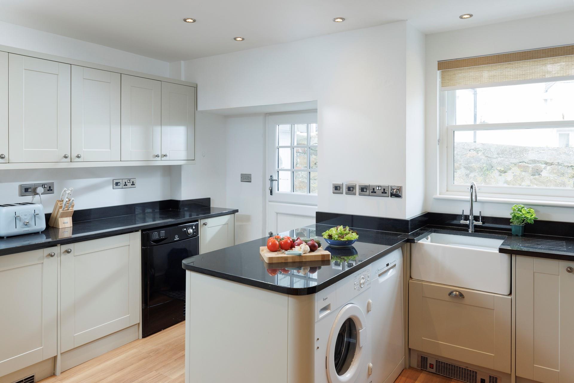 The kitchen is modern and fully equipped for preparing and cooking meals.