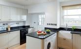 The kitchen is modern and fully equipped for preparing and cooking meals. - Thumbnail Image
