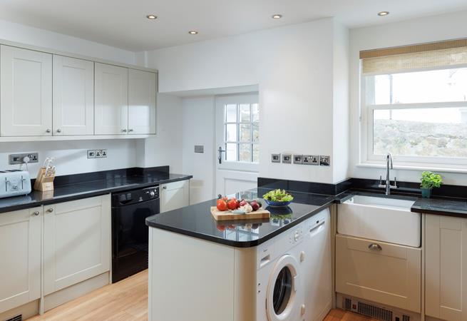 The kitchen is modern and fully equipped for preparing and cooking meals.