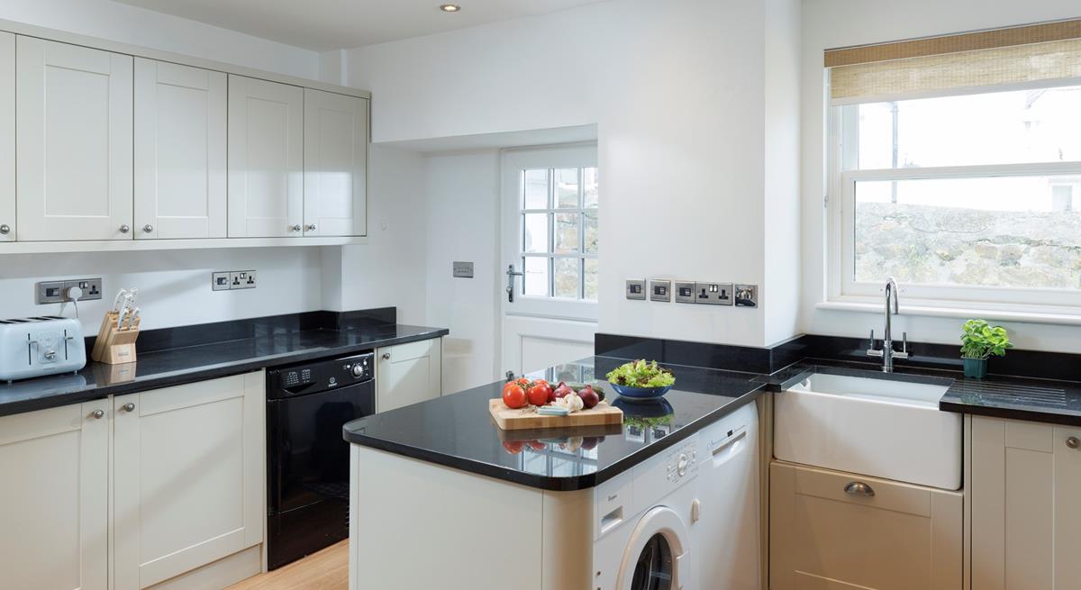 The kitchen is modern and fully equipped for preparing and cooking meals.