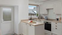 The kitchen is modern and fully equipped for preparing and cooking meals.