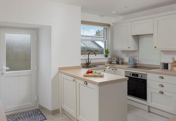 The kitchen is modern and fully equipped for preparing and cooking meals.