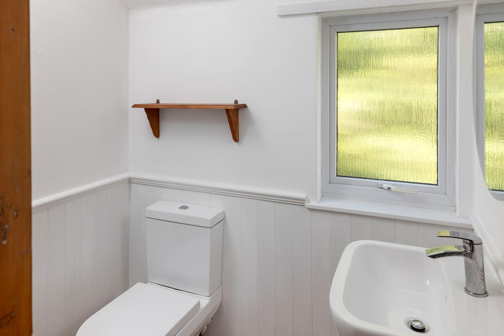 The bathroom is modern and minimalist, with plenty of natural light.