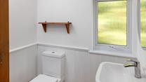 The bathroom is modern and minimalist, with plenty of natural light.