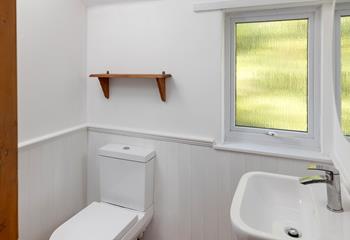 The bathroom is modern and minimalist, with plenty of natural light.