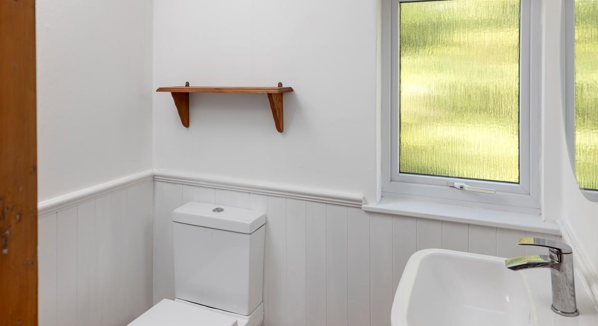 The bathroom is modern and minimalist, with plenty of natural light.