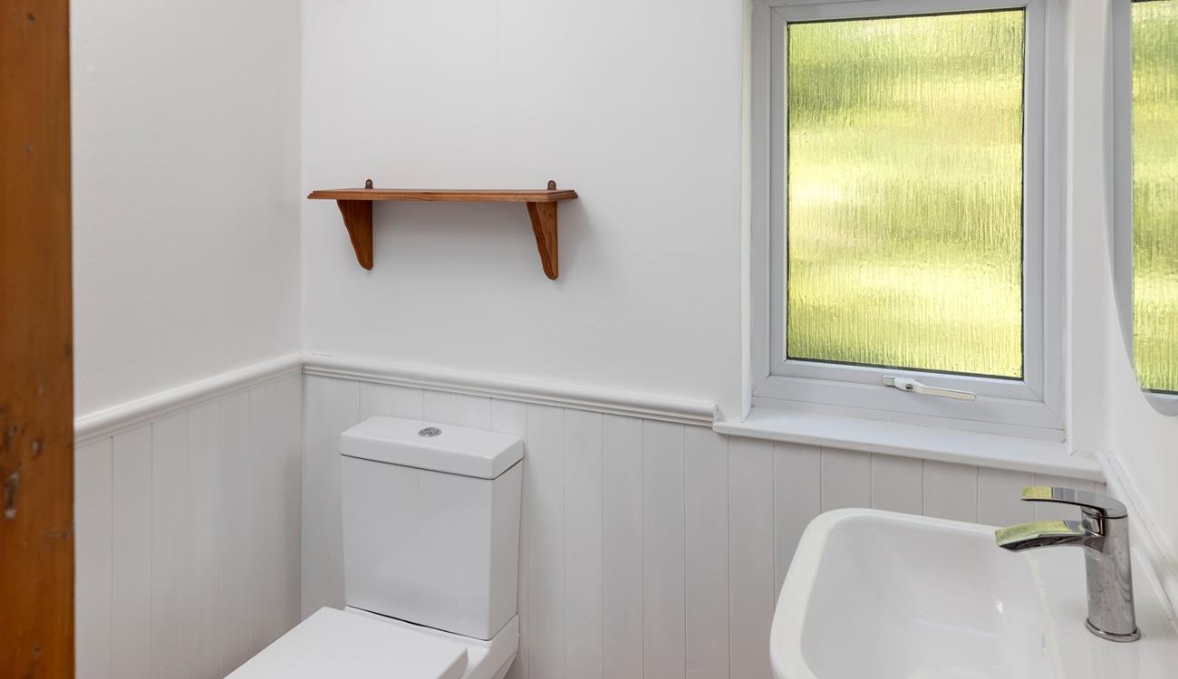 The bathroom is modern and minimalist, with plenty of natural light.