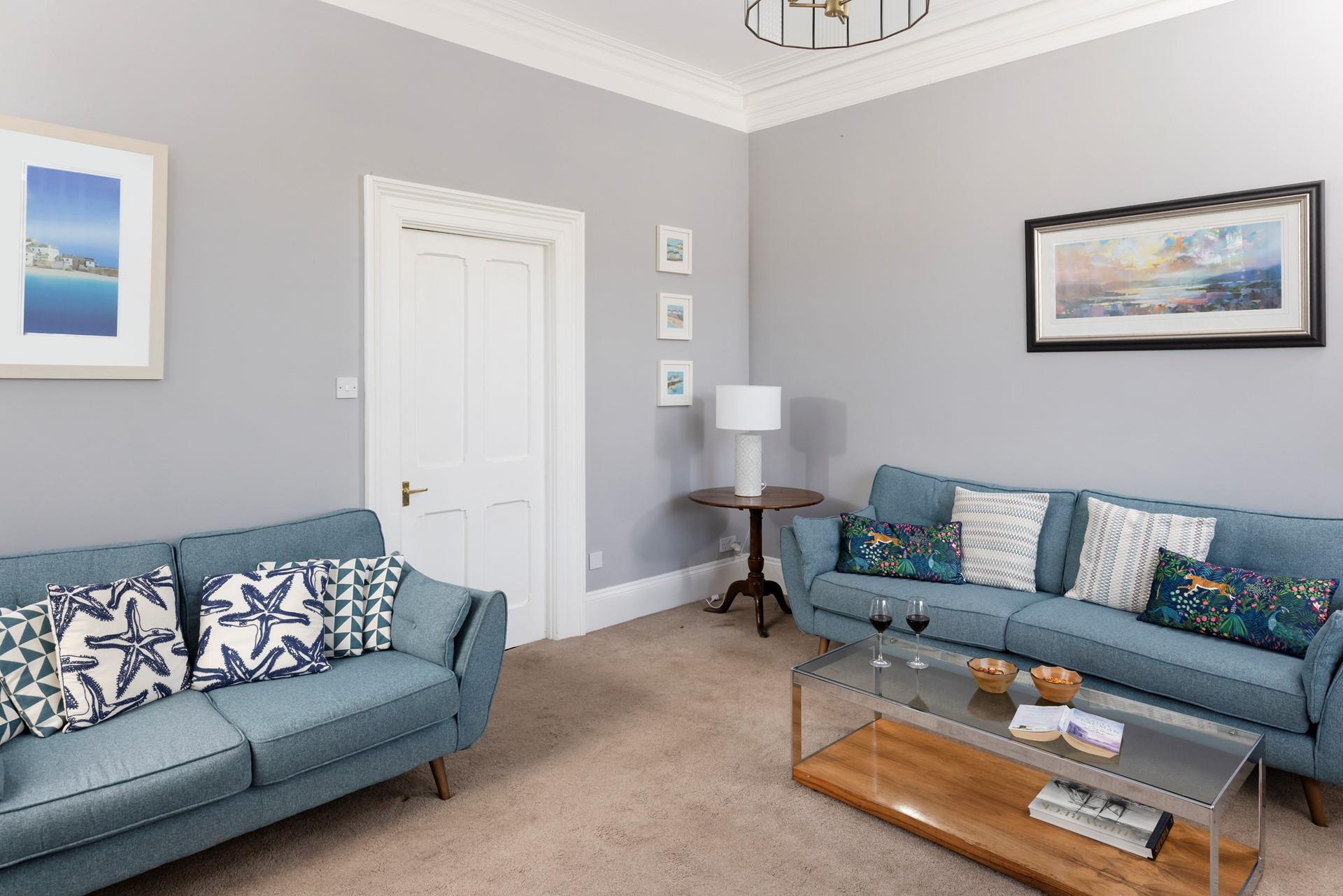 The sitting room is spacious and filled with comfortable furnishings.