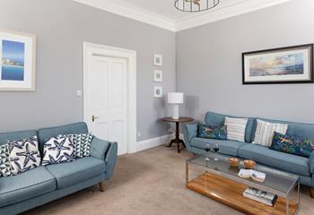 The sitting room is spacious and filled with comfortable furnishings.