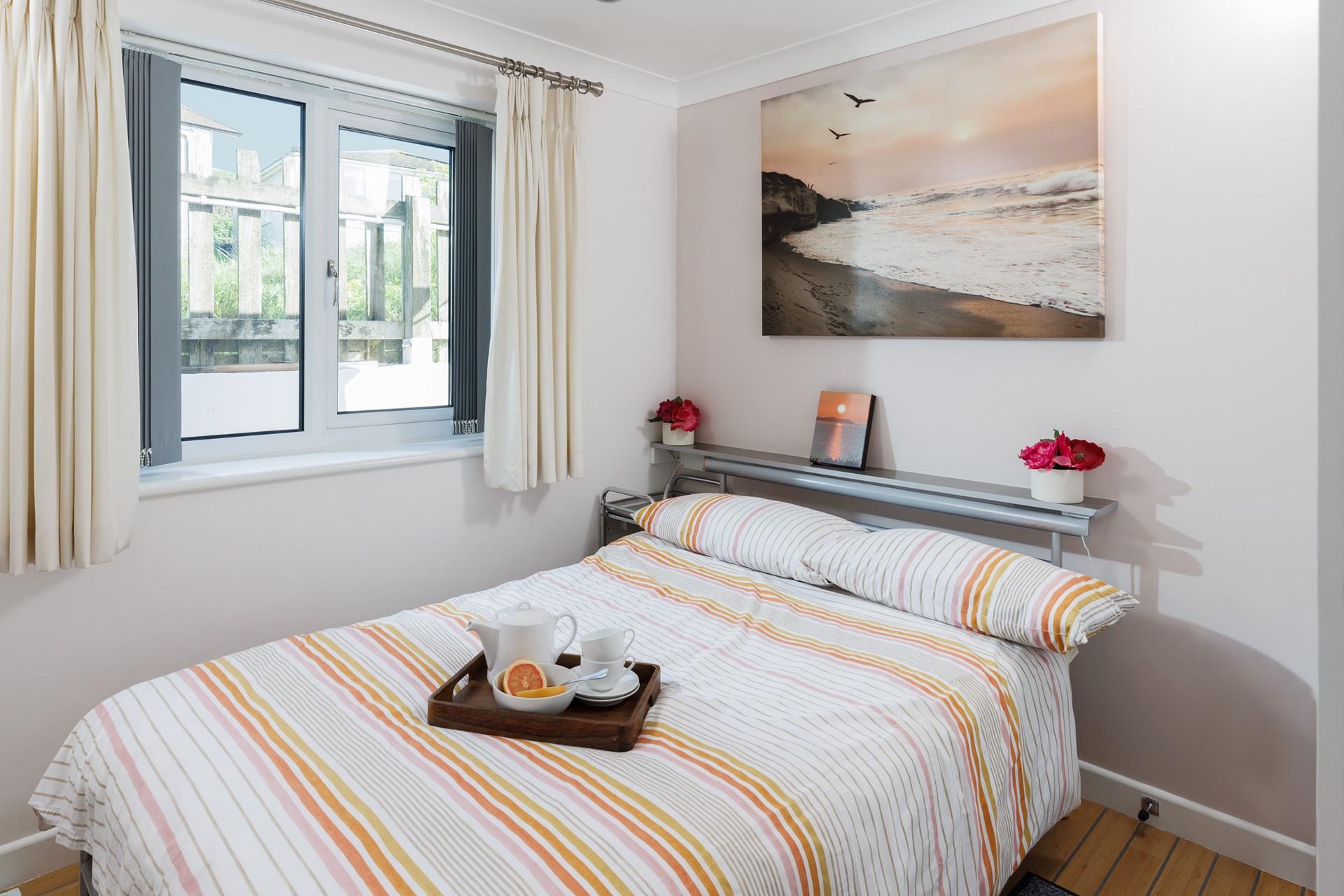 Bedroom 1 takes inspiration from the golden tones of a Cornish sunset.