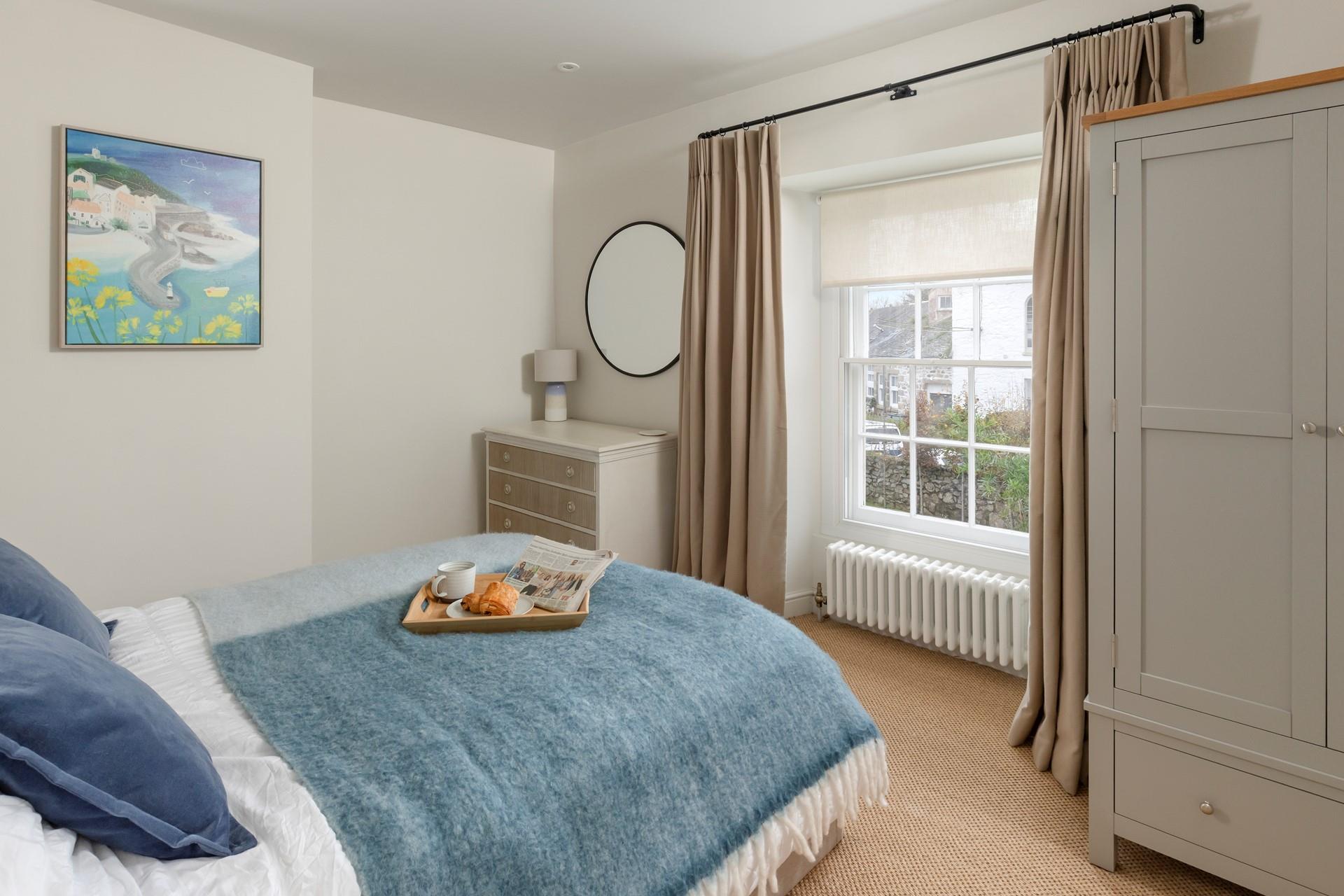 Bedroom 2 has a comfortable double bed and Cornish artwork.