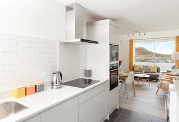 The kitchen is modern and sleek for preparing and cooking at mealtimes.