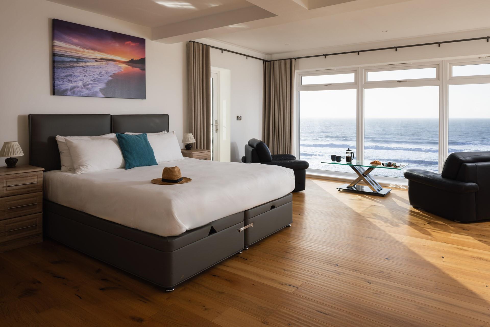 The bedroom is spacious and filled with light from the stunning windows.