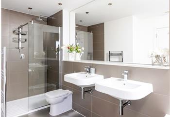 The family bathroom has a spacious shower and dual sinks.