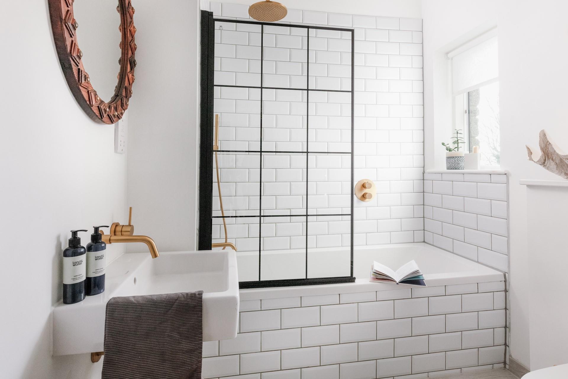 Light and bright, the modern family bathroom has a bath and shower.