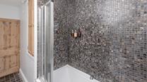 The stylish bedroom boasts a rainfall shower and bath.