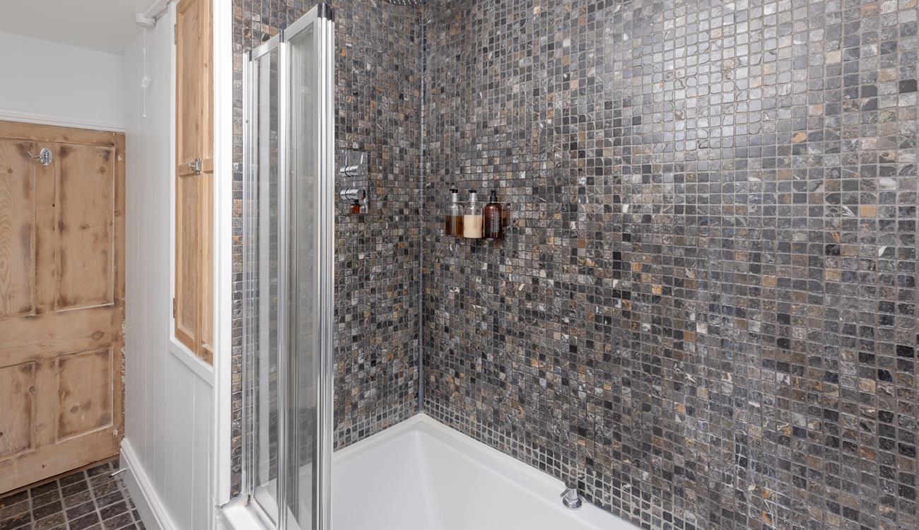 The stylish bedroom boasts a rainfall shower and bath.