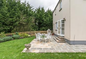 A picturesque stream runs along the back of the garden, beyond the fence.