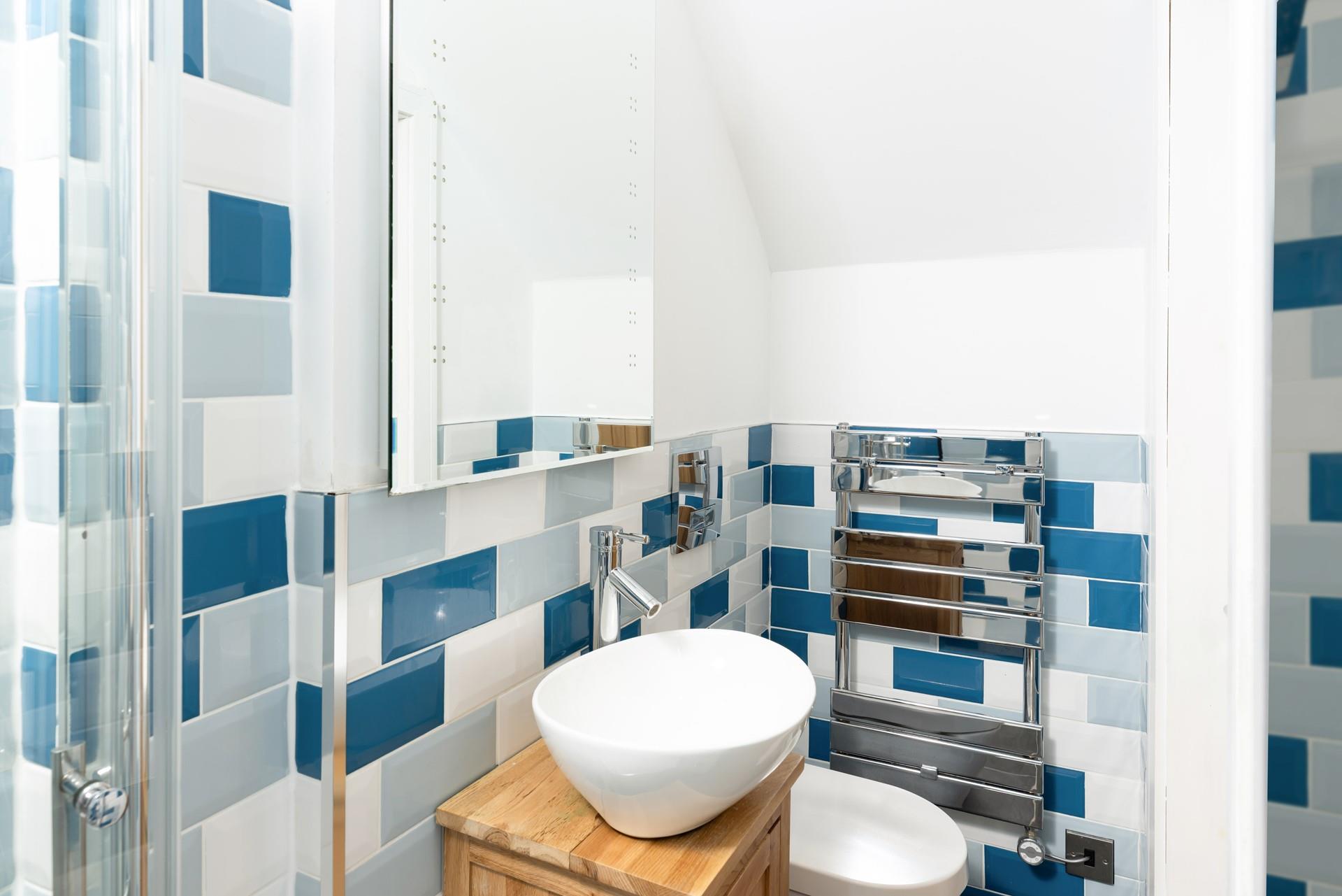 The modern bathroom features cool, coastal-inspired tiles.