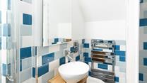 The modern bathroom features cool, coastal-inspired tiles.