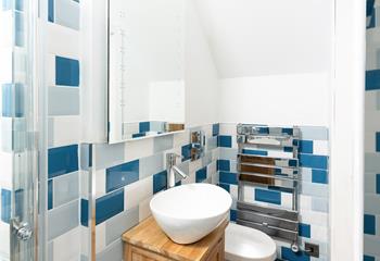 The modern bathroom features cool, coastal-inspired tiles.