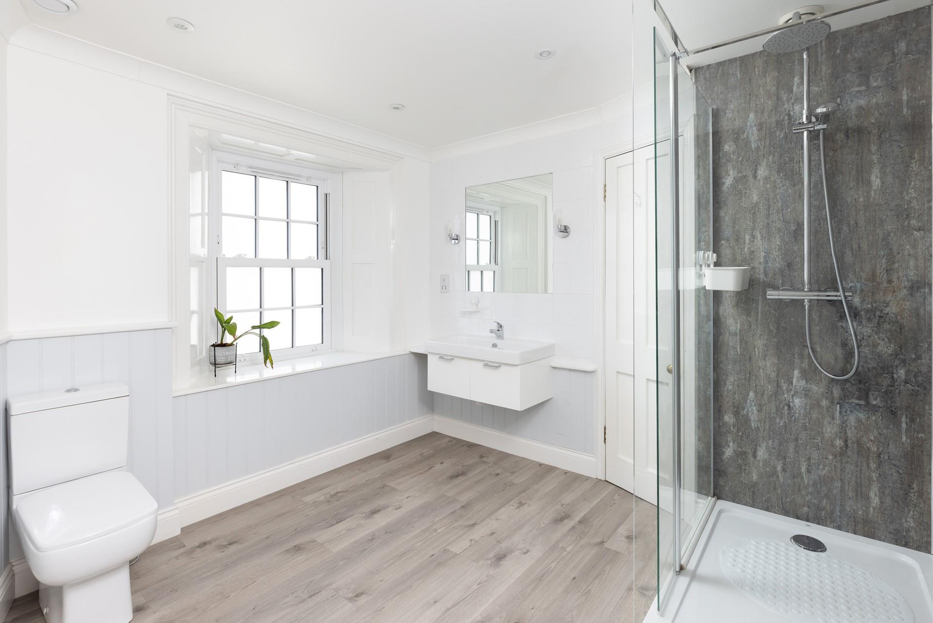 The spacious bathroom has a walk-in rainfall shower.