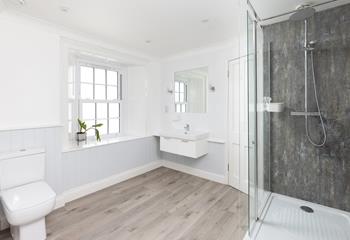 The spacious bathroom has a walk-in rainfall shower.