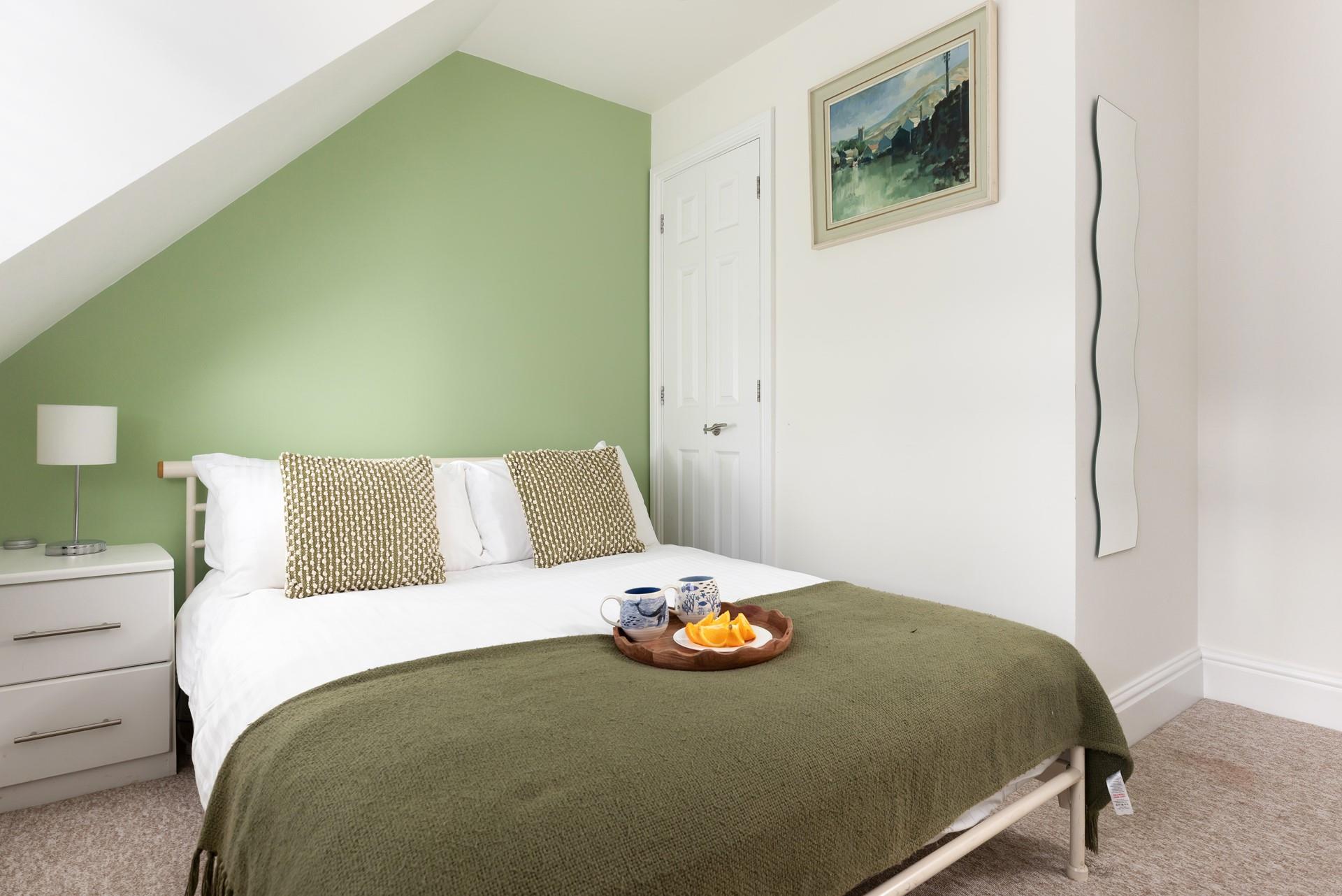 Calming green hues create a relaxing space in bedroom 3.