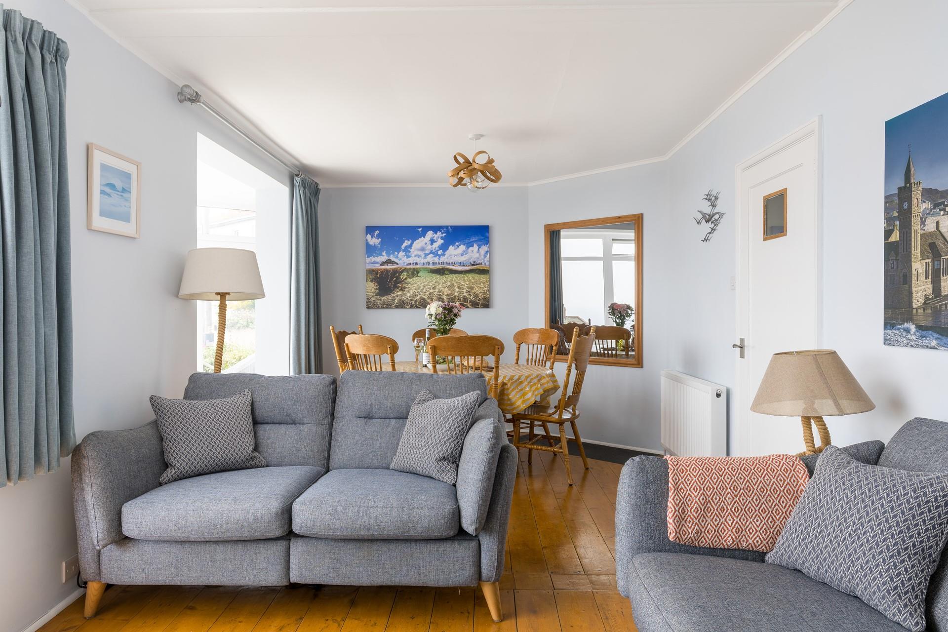 The comfortable living area boasts sea views from the sofa and dining table.