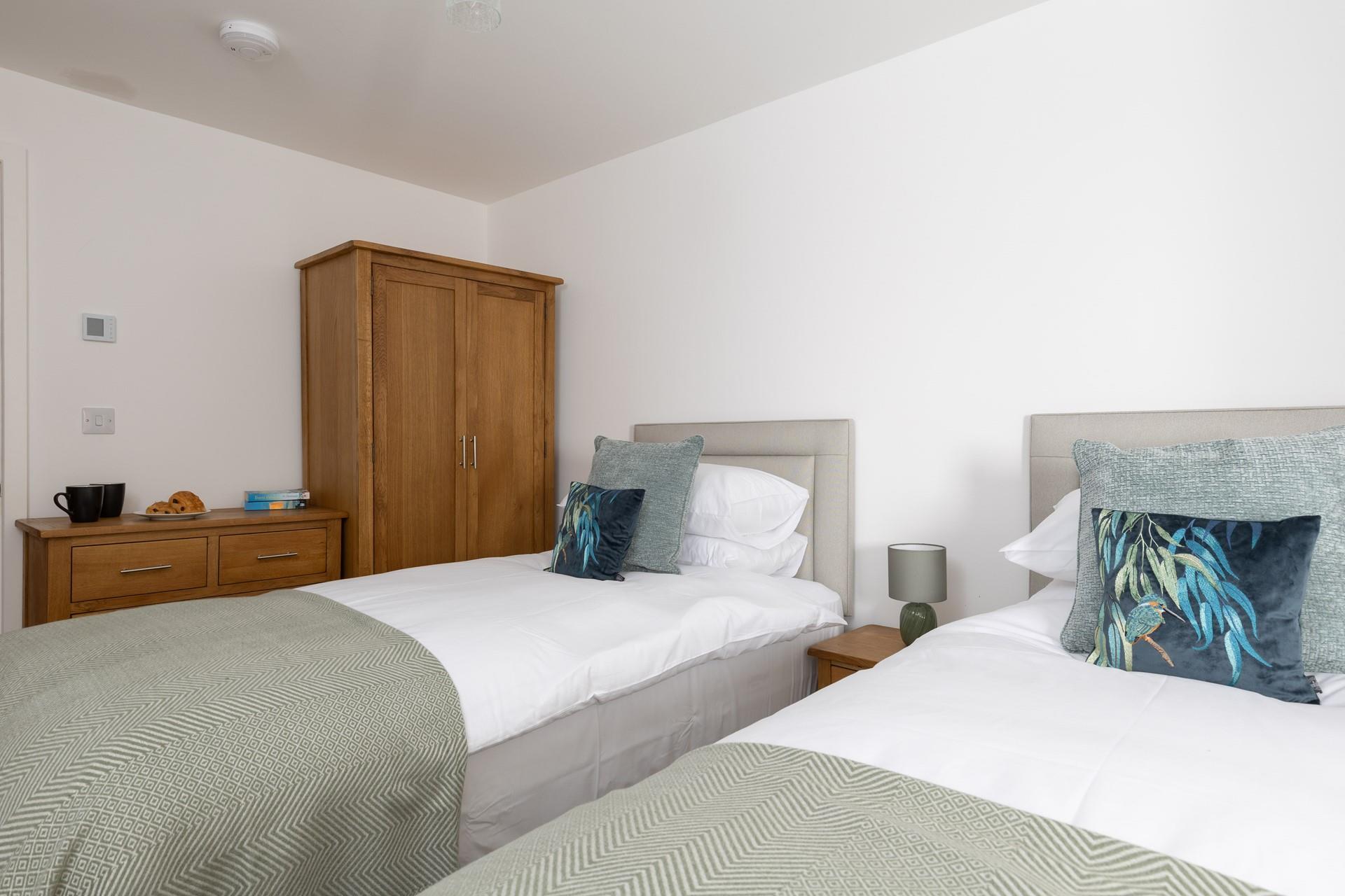 Bedroom 2 has twin beds and plenty of storage, suitable for adults or children.