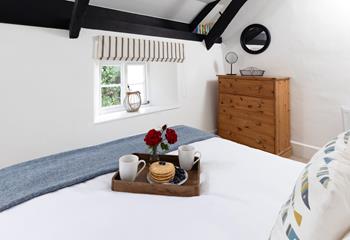 The bright bedroom is the perfect place to relax after a day of exploring. 
