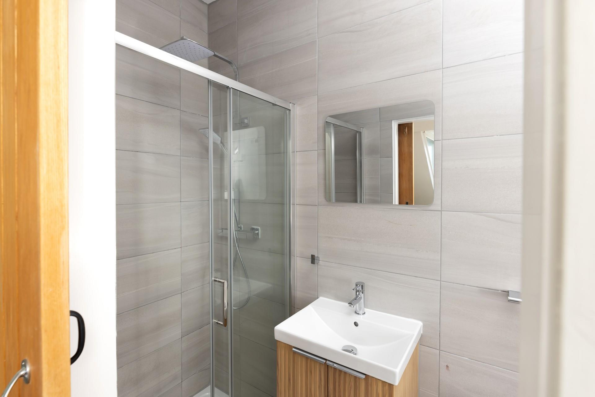 Step into the sleek en suite shower room.