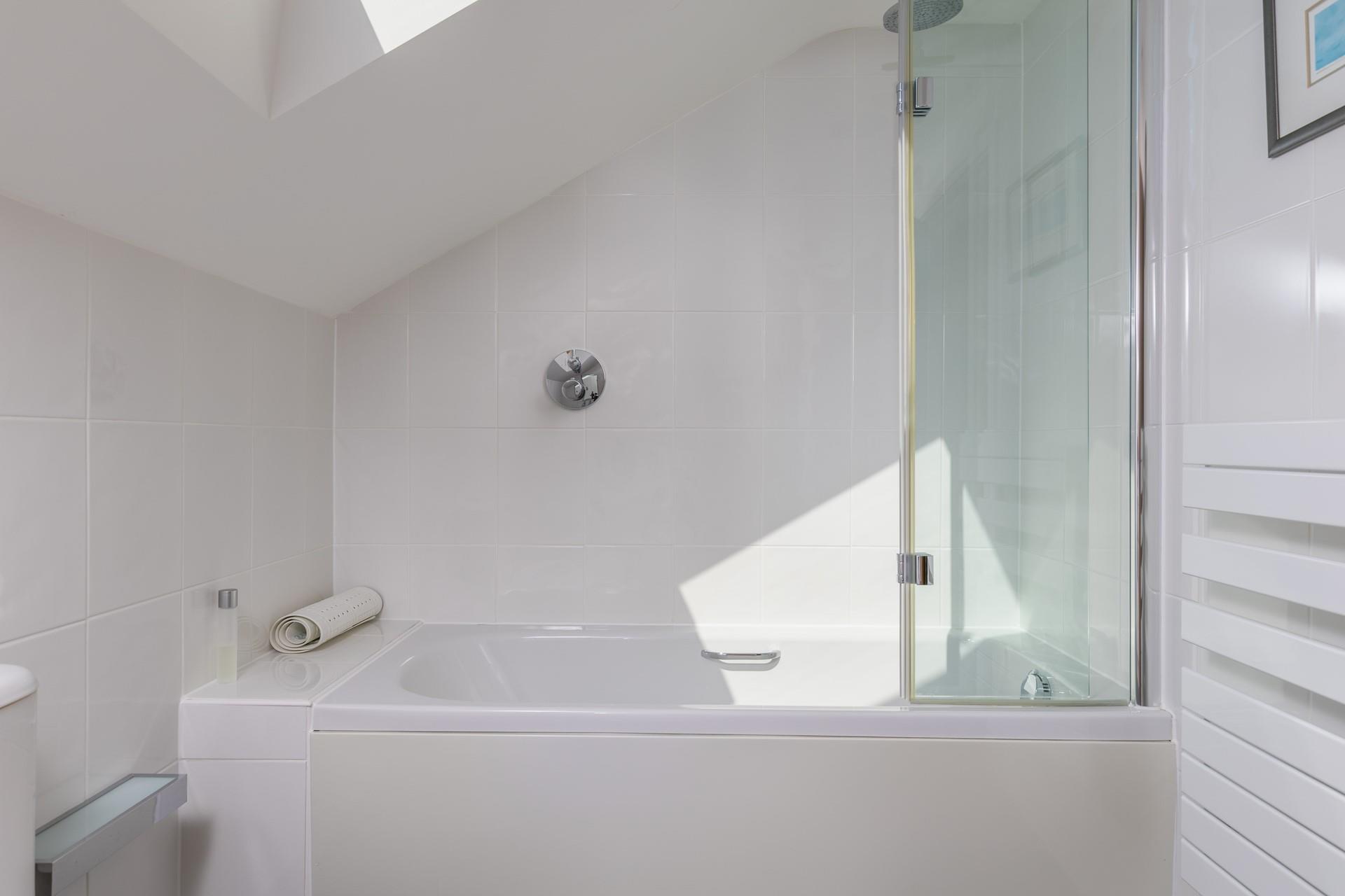 The family bathroom has a rainfall shower over bath.