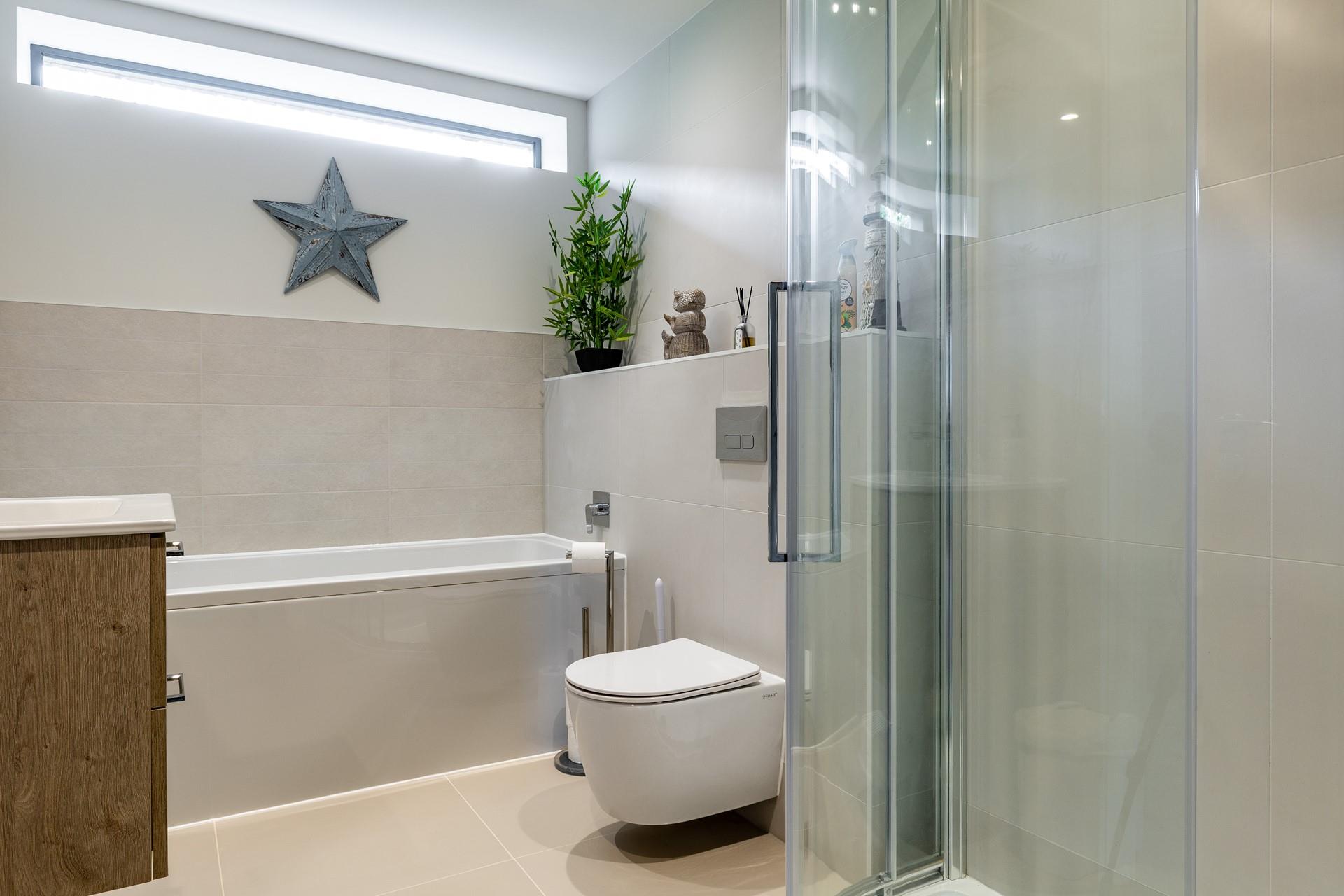The contemporary family bathroom has a shower and bath.