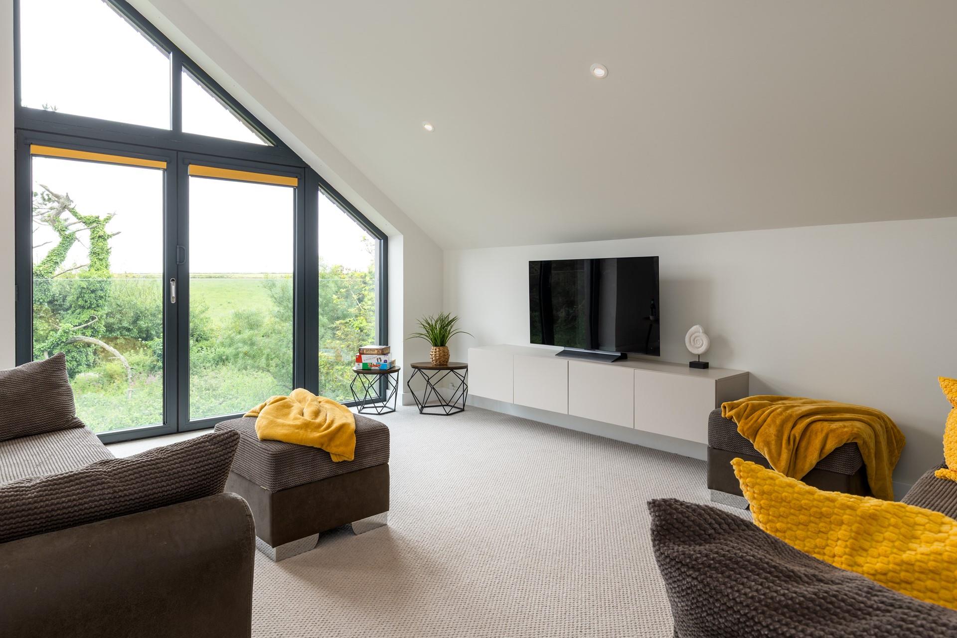 Floor-to-ceiling windows overlook the Cornish countryside.