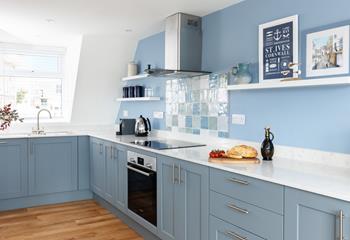 The stylish kitchen in shades of blue is a reflection of the coastal location.