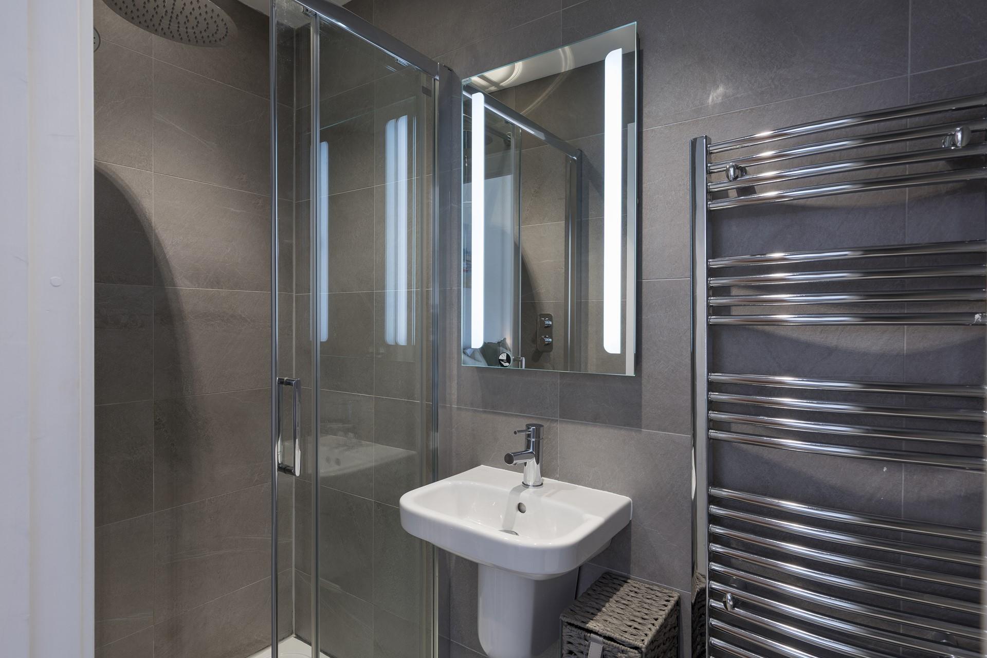 The sleek and stylish en suite in bedroom 2 has a rainfall shower.