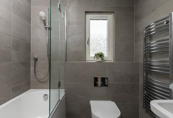 The modern family bathroom has a shower and bath.